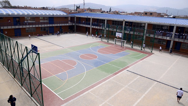 Foto general del patio del colegio Gran colombiano, con varios niños jugando en la cancha de fútbol, reconstruido por la Alcaldía de Bogotá