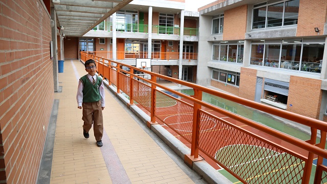 Pasillos del colegio OEA Antonio Santos, con un niño caminando por los pasillos, reconstruido por la Alcaldía de Bogotá