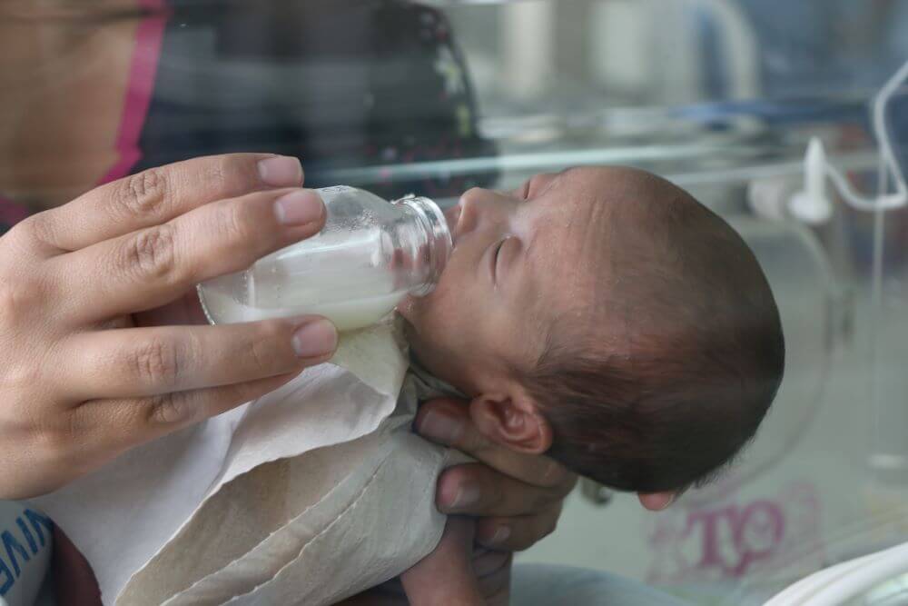 Imagen de un bebé prematuro recibiendo la leche.