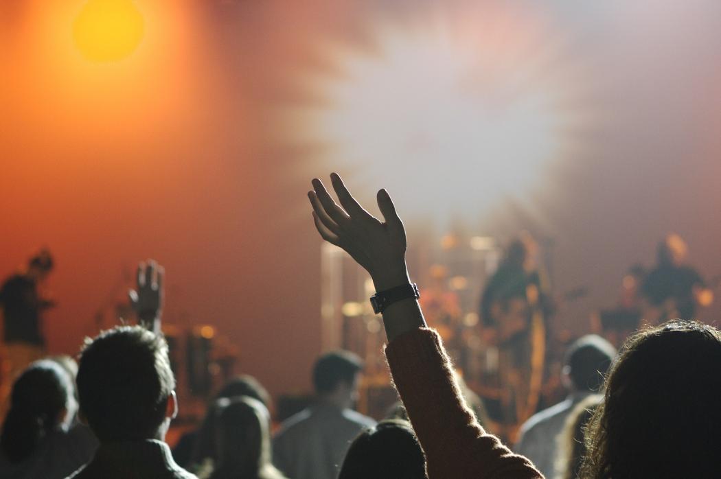 Varias personas en un festival alzando las manos y bailando con la música 
