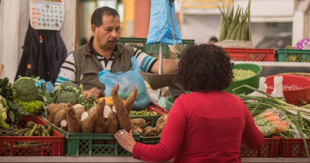 Imagen de vendedor con usuaria en Plaza de Mercado.