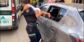 En la foto una mujer policía rescatando al menor de dos años encerrado en un carro