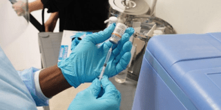 Foto que muestra una enfermera colocando una vacuna