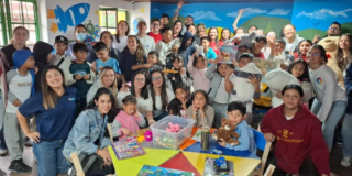 Imagen de niños, niñas y voluntarios posando para la foto en la Ludoteca.