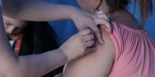 Foto que muestra una enfermera colocando una vacuna