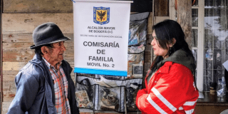 Imagen de una funcionaria de Integración Social junto a un adulto mayor