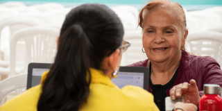 Imagen de una funcionaria atendiendo a una adulta mayor