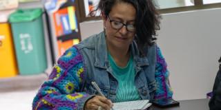 Mujer tomando nota en un cuaderno.