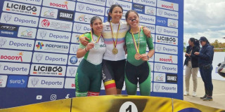 Atletas del Equipo Bogotá celebran en podio con medallas frente a panel del Campeonato Nacional de Paracycling Pista y Ruta