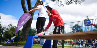 Niña realiza ejercicio de equilibrio con acompañamiento del IDRD en parque recreativo