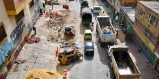 Foto que muestra una vía en construcción y volquetas