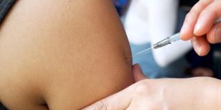 Foto que muestra una enfermera colocando una vacuna en un brazo