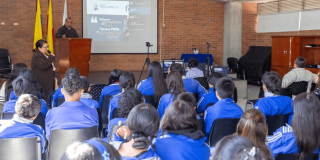 Foto que muestra estudiantes sentados en un salón de clases