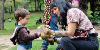 Imagen de la artista formadora con un niño en un parque.