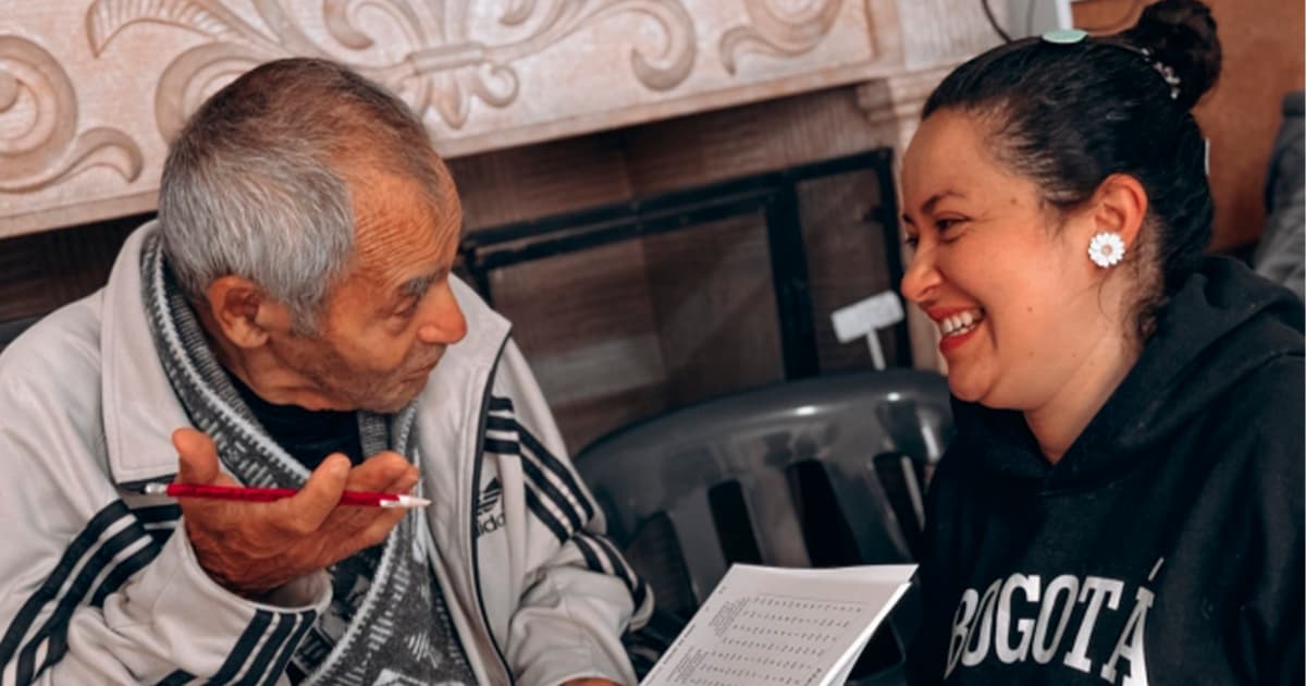 En la foto dos personas de la tercera edad hablando y sonriendo