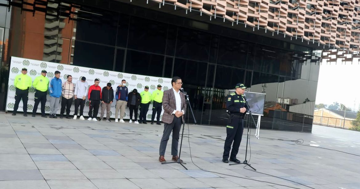 Imagen de la rueda de prensa en la que se ve al secretario de seguridad y detrás de él a los capturados