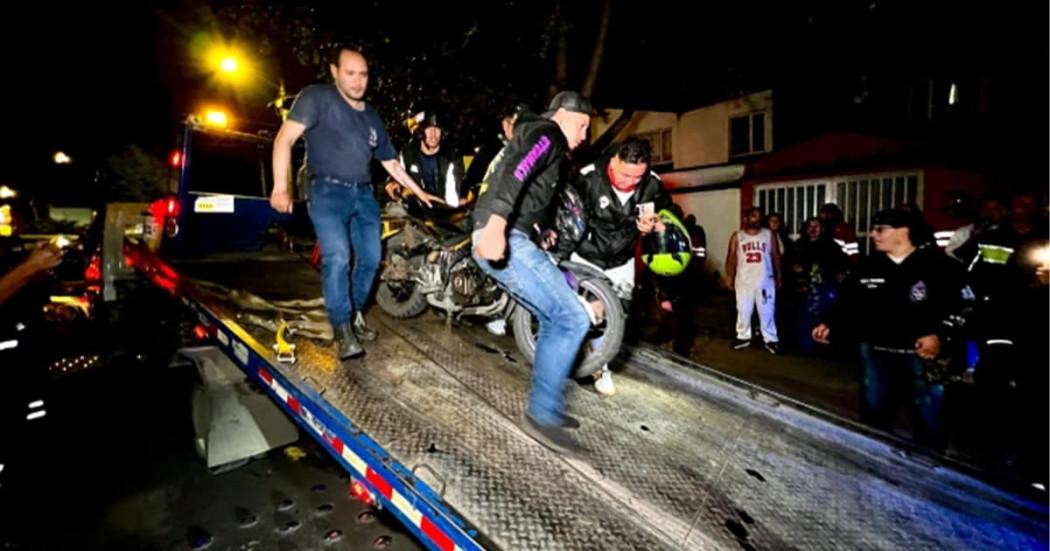 En la foto personas bajando de una cama baja una moto inmovilizada