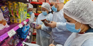 Foto de funcionarios de salud inspeccionan productos en un establecimiento para verificar su calidad y garantizar la seguridad alimentaria durante Halloween.