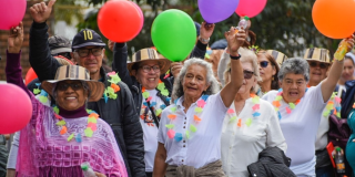 Imagen de personas mayores felices alzando unas bombas