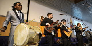 Imagen de una orquesta de personas con discapacidad tocando en tarima.