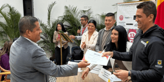 Imagen de un funcionario entregando un diploma a un comerciante