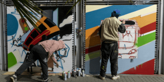 Imagen de dos artistas interviniendo una estación de TransMilenio