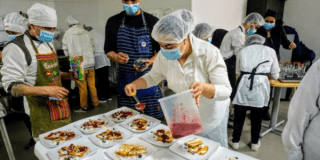 Imagen de dos personas preparando comida