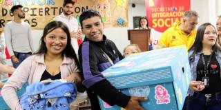 Una pareja de jóvenes sonriendo recibiendo su ‘Cuna con Amor