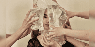 Imagen de la cara de una mujer, a su alrededor hay muchas manos de personas que tienen bolsas plasticas llenas de agua que al presionar su cara se ve desfigurada.