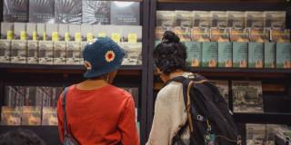 Imagen de dos mujeres observando un stand de libros del IDPC