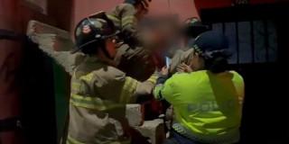 En la foto están rescatando tres bomberos y una policía al niño