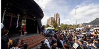 Imagen de un escenario donde abajo hay muchas personas disfrutando de un evento.