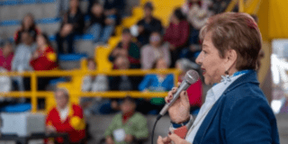 Foto de una persona mayor hablando por un microfono