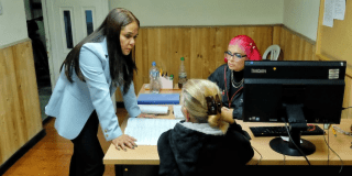 Imagen de funcionarias atendiendo a una mujer en una oficina