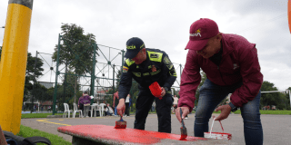 Imagen de varias personas pintando una banca de parque