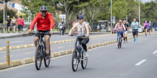 Personas en bicicleta recorren ciclovía urbana acompañadas por corredores y peatones Bogotá