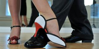 Pareja de bailarines de tango. Primer plano de sus pies.